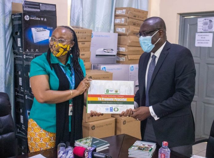 Rev. Dr. Ernest Adu-Gyamfi, Board Chairman of NPC presenting report on Elections 2020 sensitization sessions to Angela Lusigi, UNDP Resident Representative in Ghana