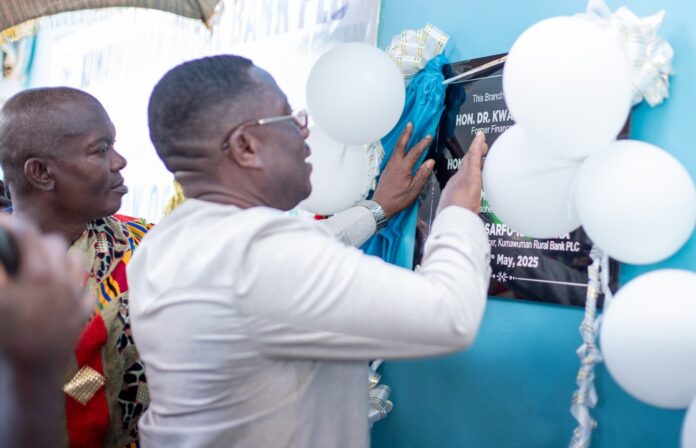Dr Alex Adomako-Mensah, Board Chairman, being assisted to officially unveil the plaque to open the newly constructed Drobonso branch building